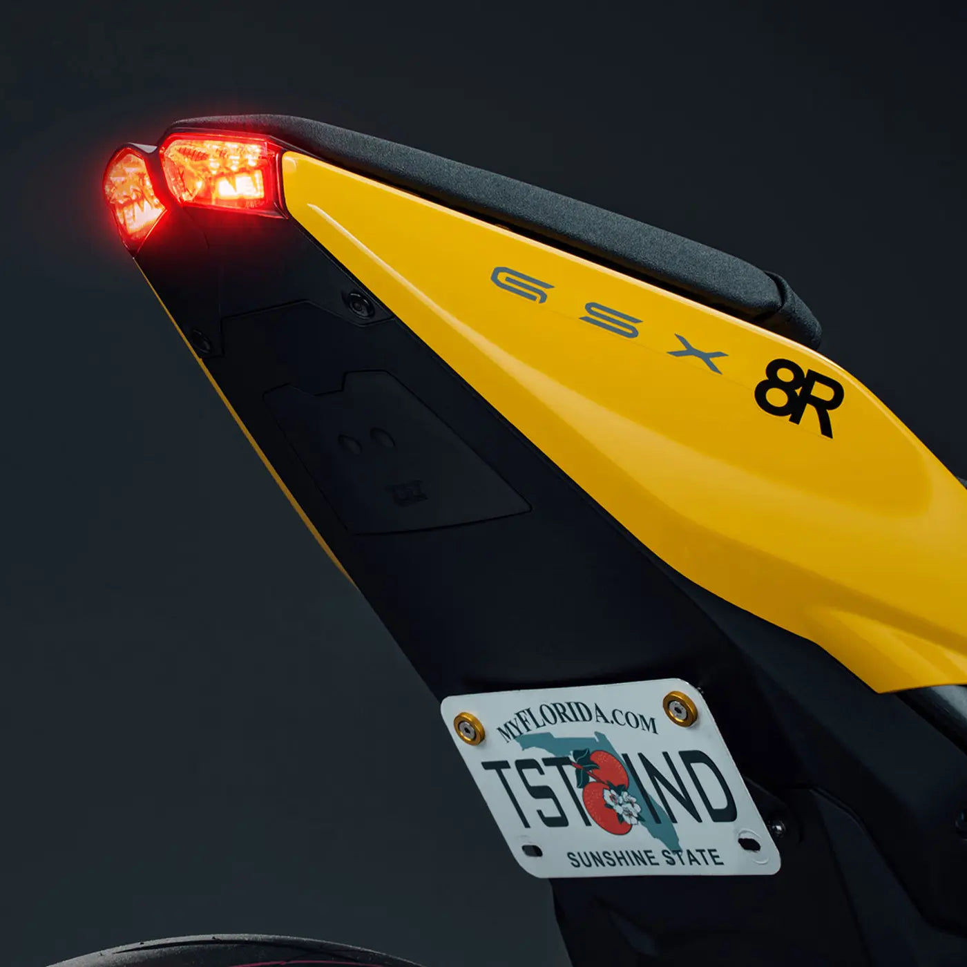 Close up image of the TST Industries Undertail Closeout, LED Integrated Tail Light, and Low Mount Tail Tidy on the rear of a yellow Suzuki GSX-8R,