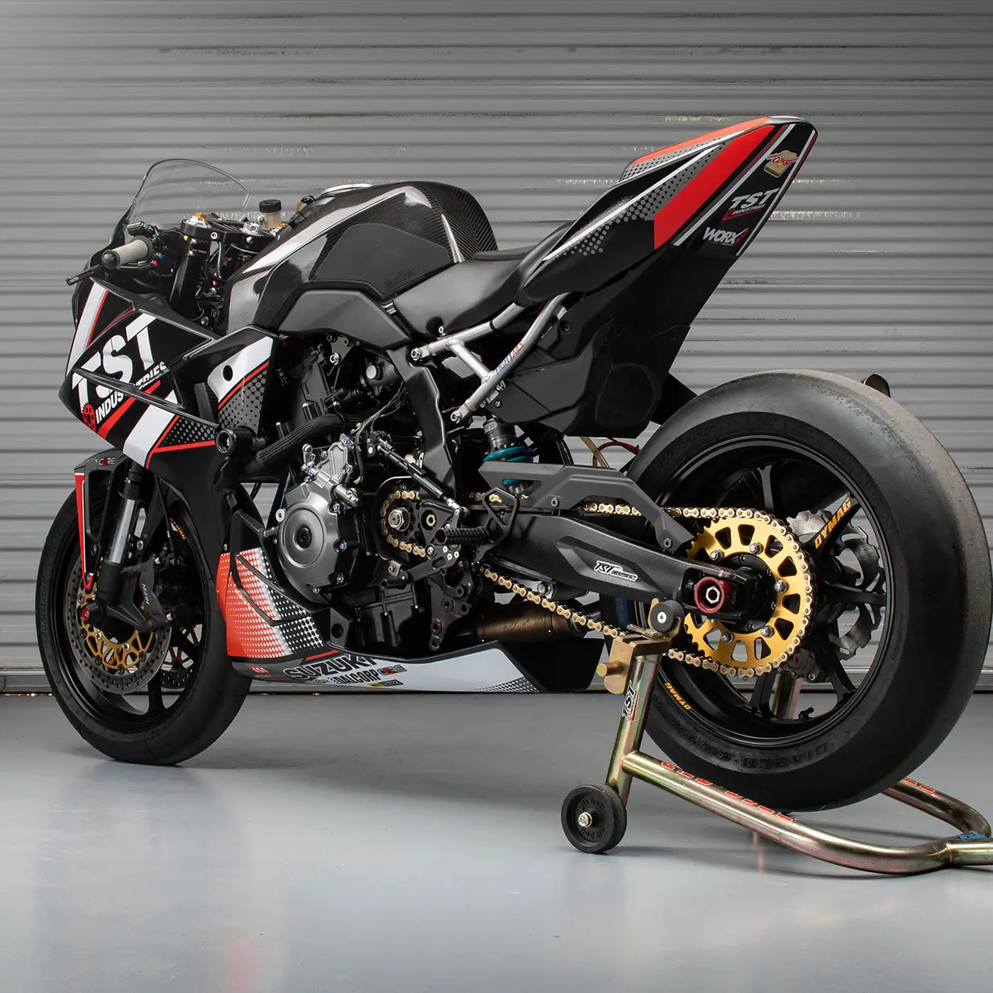 TST Industries WORX GSX-8R race bike on a rear Pit Bull swingarm stand with a grey background.