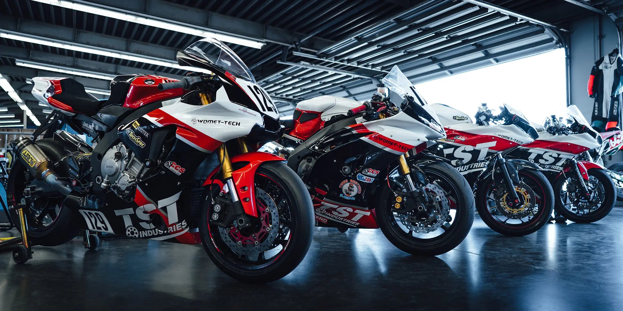 TST Industries WORX race bikes lined up in the track paddock.
